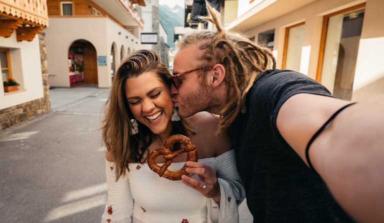 man and woman smiling while holding brown heart shaped balloons, trans woman, dating