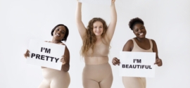 trois femmes tenant des pancartes avec des déclarations sur la positivité corporelle