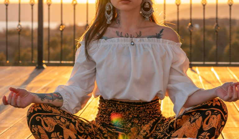 Ganzkörperaufnahme einer sitzenden Frau bei Sonnenuntergang