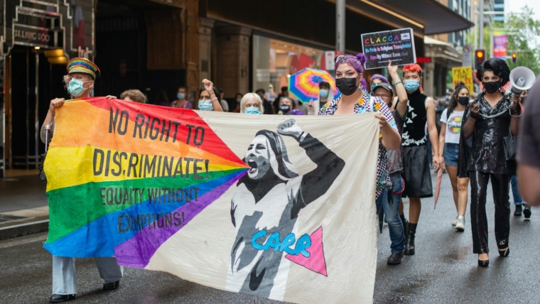 What are some legal rights for transgender women? A comprehensive guide 1 a group of people walking down a street holding a rainbow flag